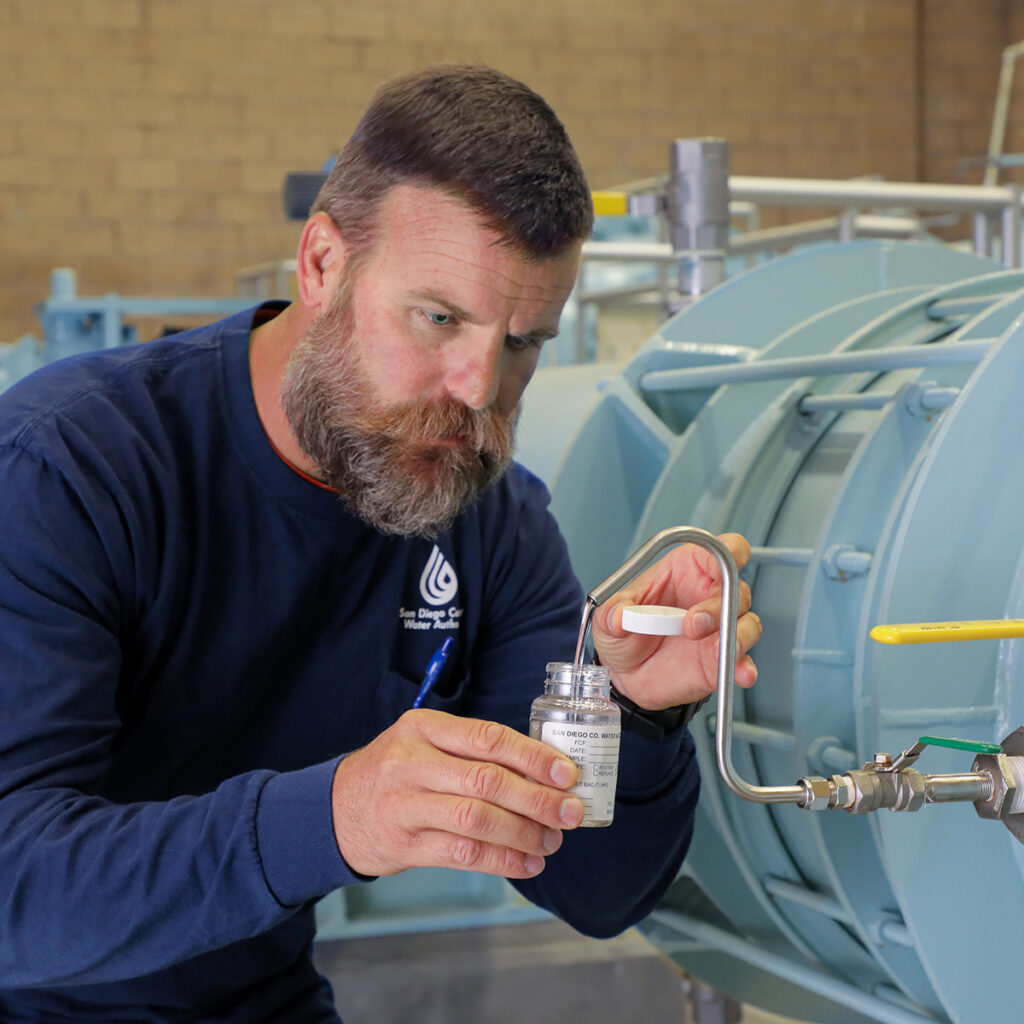 man taking a water sample for testing